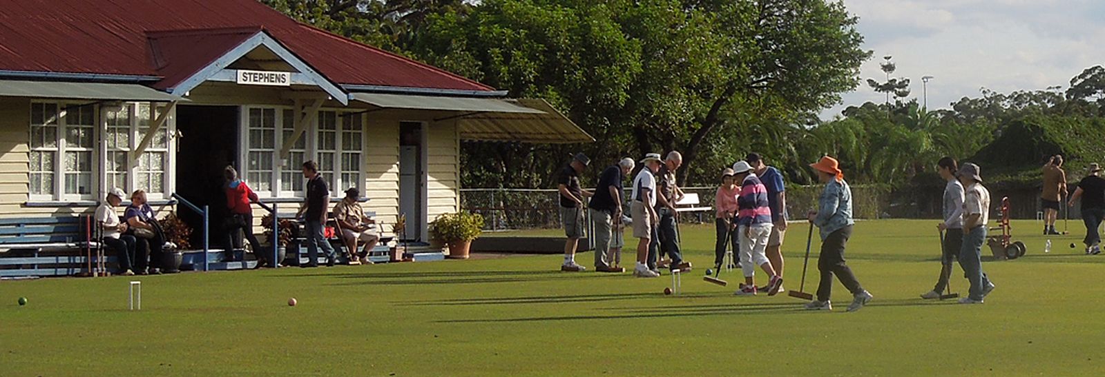 Members playing croquet on the lawn beside the Stephens clubhouse, late afternoon