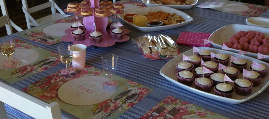 The clubhouse set up for a party, a long table of cakes and platters