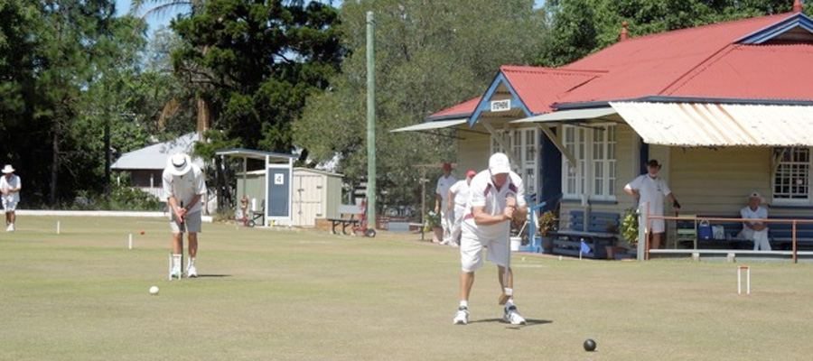 Two members playing in front of the red-roofed Stephens clubhouse
